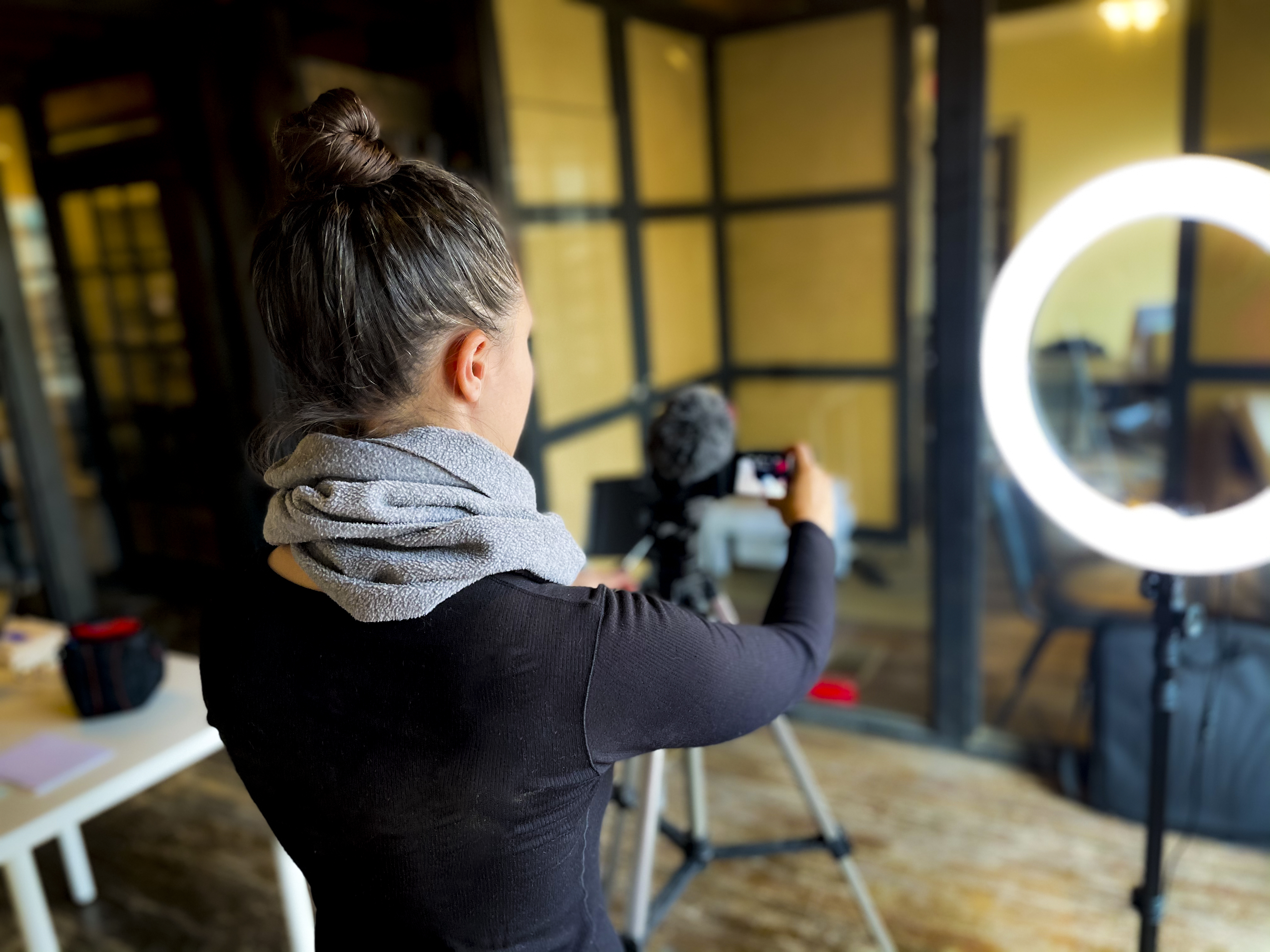 Gabrielle Molina filming video content with a camera and ring light